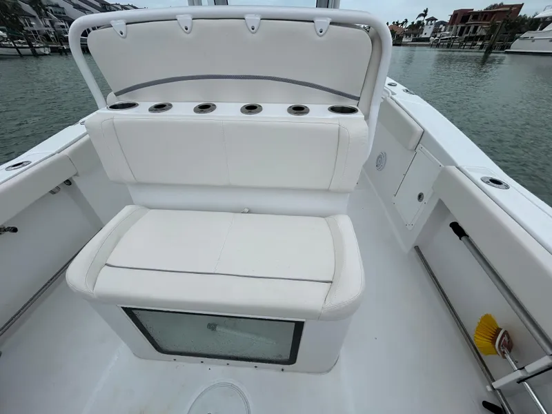 Slide: The Image of 2024 Sea Hunt Gamefish 27 boat interior with coffin box, white seating, and rod holders. - 8