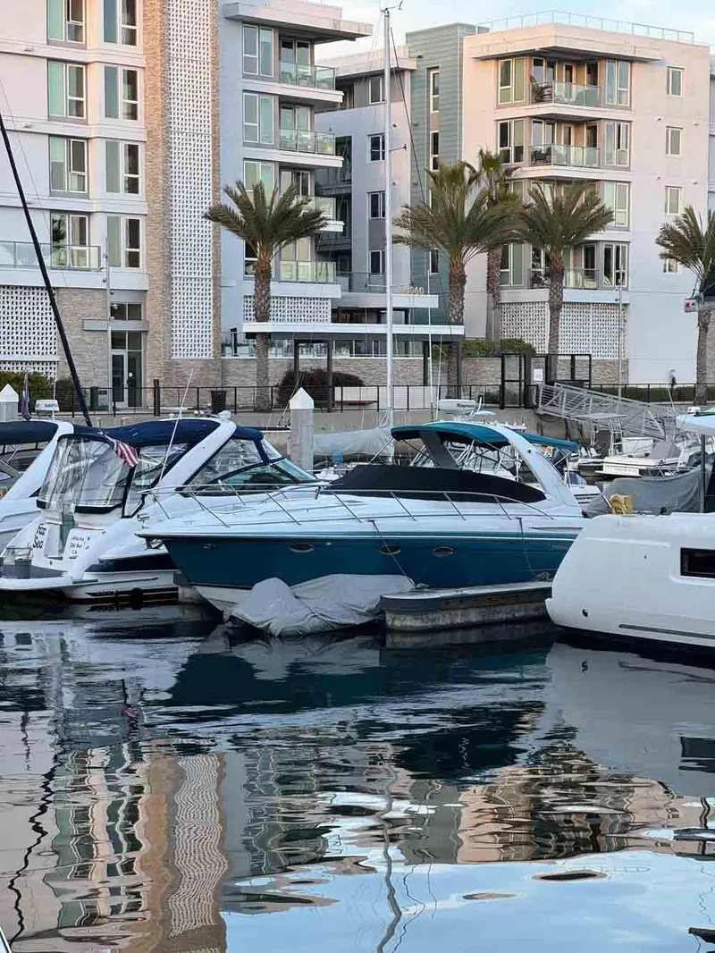 Slide: The Image of 2005 Formula 31 Performance Cruiser docked in a marina, surrounded by modern buildings and palm trees. - 21