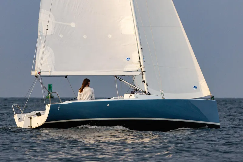 Slide: The Image of 2026 J Boats J/7 sailboat on open water, featuring sleek blue hull and white sails. - 4