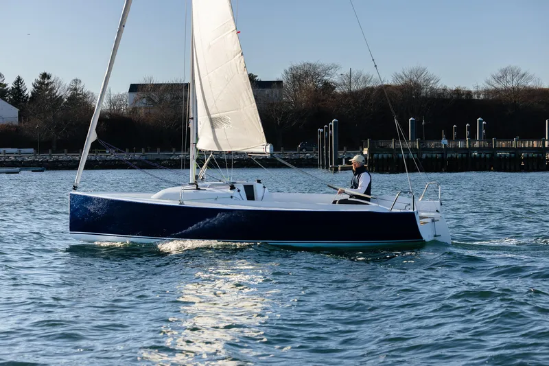 Slide: The Image of 2026 J Boats J/7 sailboat cruising on calm waters near a marina. - 7