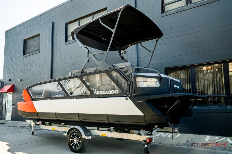 Slide: The Image of 2024 Sea-Doo Switch SPORT 21 230HP boat on trailer, parked outside a building. - 21