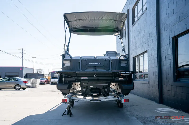 Slide: The Image of 2024 Sea-Doo Switch SPORT 21 230HP boat, rear view, parked outdoors. - 3