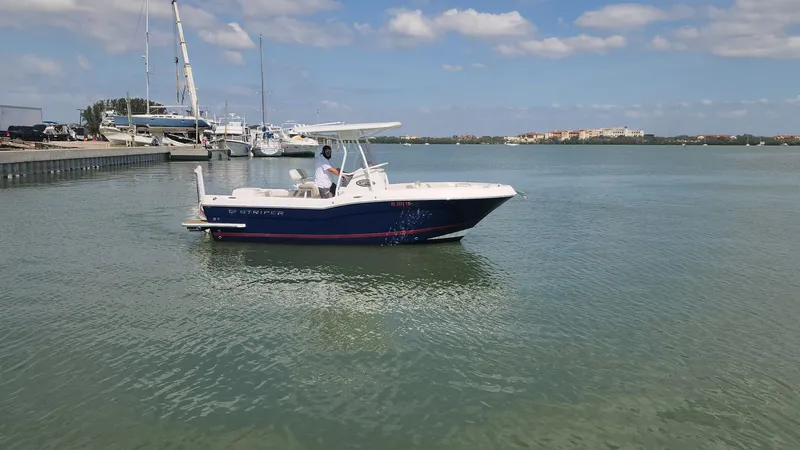 Slide: The Image of 2014 Striper 220 Center Console boat on calm water, clear sky background. - 0