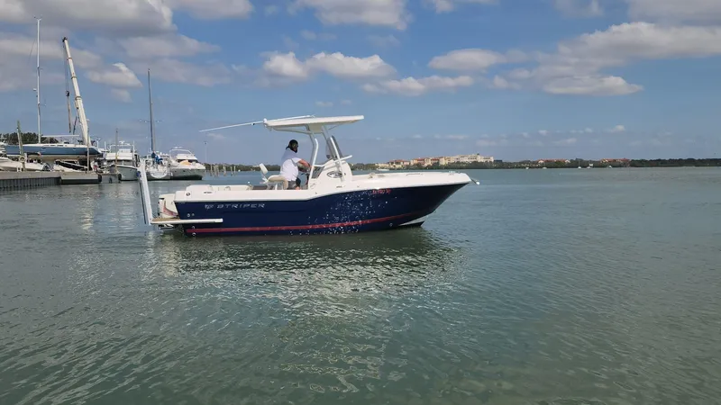 Slide: The Image of 2014 Striper 220 Center Console boat on calm water under a partly cloudy sky. - 22