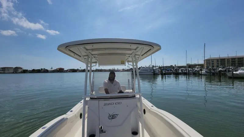 Slide: The Image of 2014 Striper 220 Center Console boat on calm water near marina under clear sky. - 27