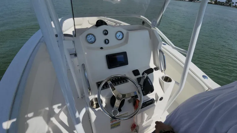 Slide: The Image of 2014 Striper 220 Center Console boat dashboard with steering wheel and gauges. - 4