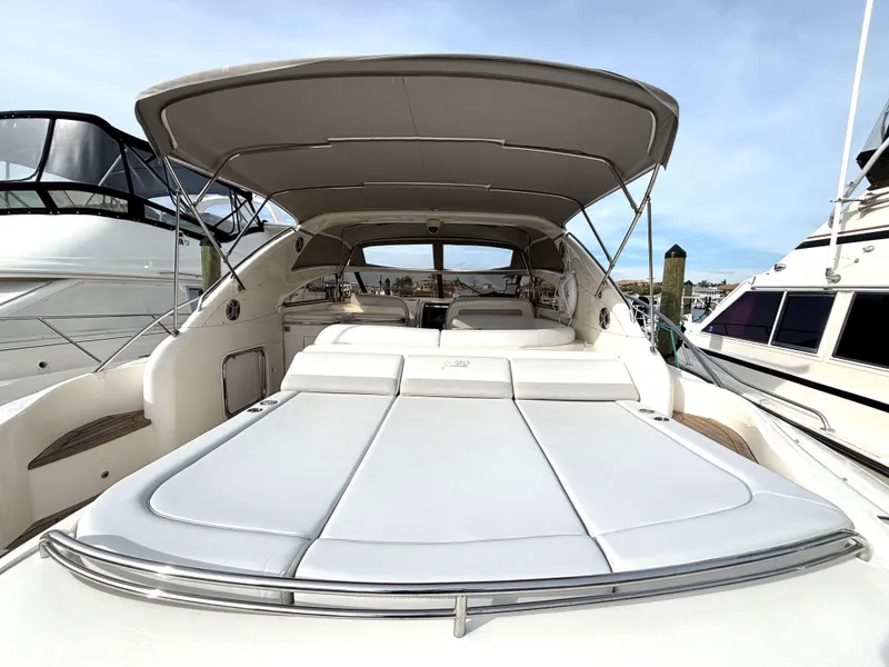Slide: The Image of 2005 Viking Princess V50 yacht with spacious sun deck and canopy, docked at marina. - 22