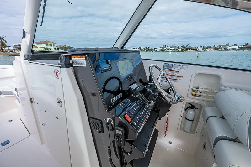 Slide: The Image of 2023 Pursuit DC 295 Dual Console boat cockpit with modern controls and steering wheel. - 17