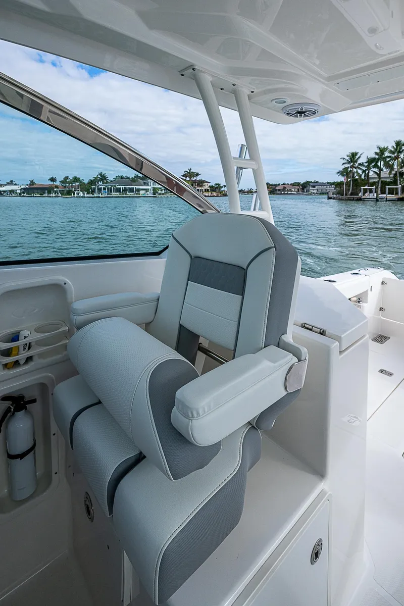 Slide: The Image of 2023 Pursuit DC 295 Dual Console boat interior with luxurious seating by the water. - 20