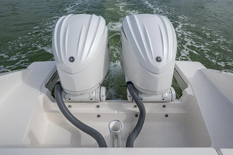 Slide: The Image of 2023 Pursuit DC 295 Dual Console with twin outboard engines on water. - 32