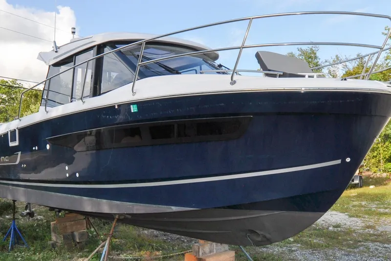 Slide: The Image of 2020 Jeanneau NC 895 boat on stands, blue hull, outdoor setting. - 8