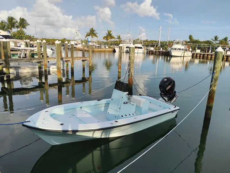 Slide: The Image of 2025 Cuda Craft 19 boat docked in a serene marina setting. - 2