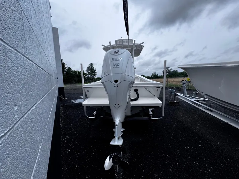 Slide: The Image of 2025 Pair Customs 24DV boat with outboard motor, parked outdoors on a cloudy day. - 3
