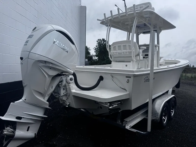 Slide: The Image of 2025 Pair Customs 24DV boat with Yamaha engine on trailer, parked outdoors. - 4