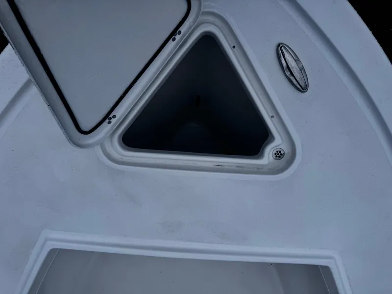 Slide: The Image of 2025 Pair Customs 24DV boat interior with triangular storage compartment. - 7