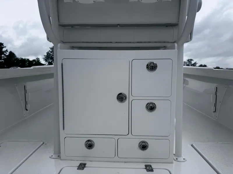 Slide: The Image of 2025 Pair Customs 24DV boat storage compartments with sleek white finish and secure latches. - 15