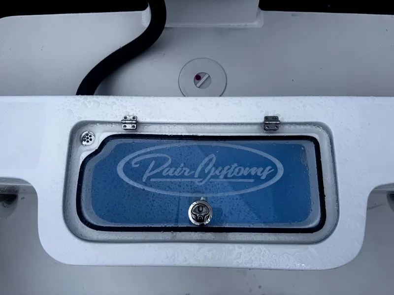 Slide: The Image of 2025 Pair Customs 24DV boat compartment with logo on blue panel. - 8