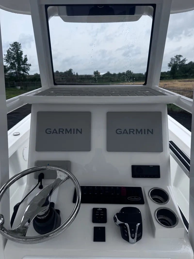 Slide: The Image of 2025 Pair Customs 24DV boat dashboard with dual Garmin displays and steering wheel. - 9