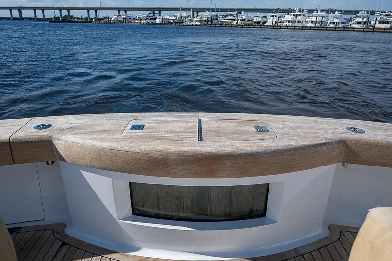 Slide: The Image of 2017 F&S Custom Express Sportfish boat with wooden deck, overlooking marina and bridge. - 16