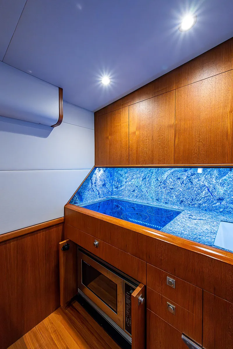 Slide: The Image of 2017 F&S Custom Express Sportfish interior with wood cabinetry and blue accent lighting. - 47