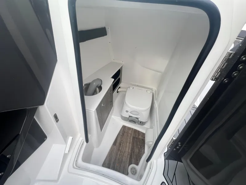 Slide: The Image of 2024 Monterey 255 Super Sport boat interior bathroom with compact toilet and sink. - 10