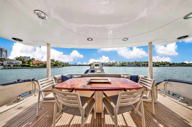 Slide: The Image of Luxury Sunseeker 150 GT yacht deck with dining area, overlooking serene waterfront. - 20