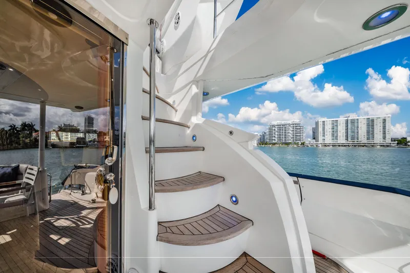 Slide: The Image of Luxury Sunseeker 150 GT yacht interior with spiral staircase, overlooking waterfront cityscape. - 22