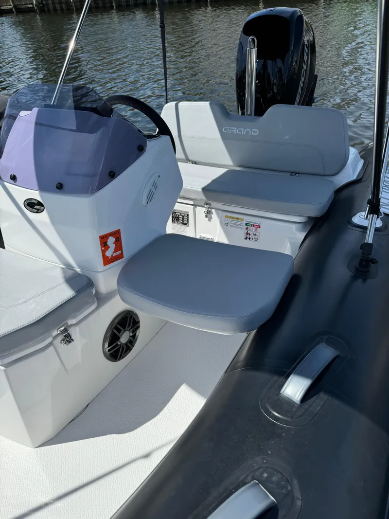 Slide: The Image of 2023 Grand Inflatables G380N boat interior with seating and steering console. - 3