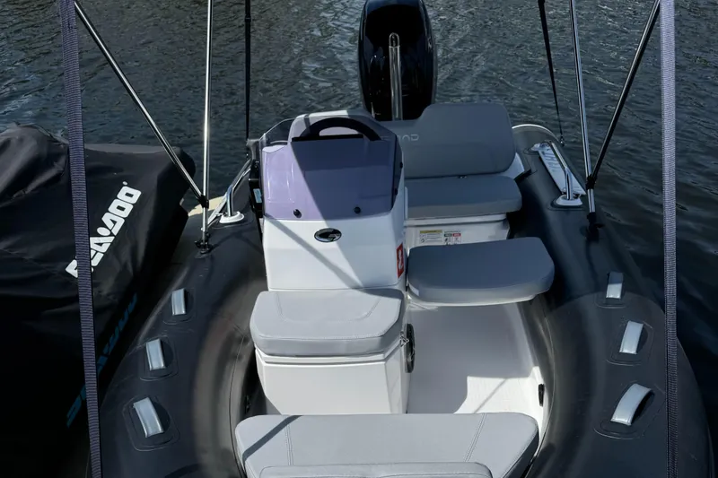 Slide: The Image of 2023 Grand Inflatables G380N boat with seating, steering console, and outboard motor on water. - 5