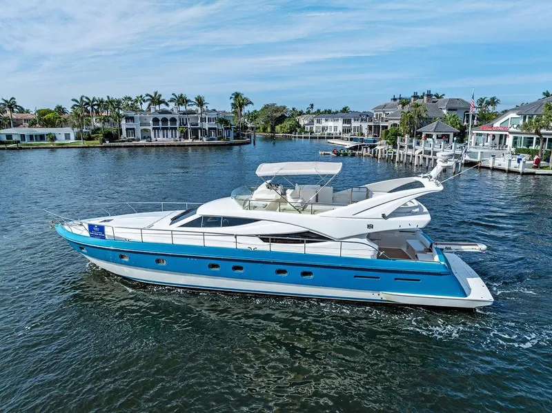 The Image of 2003 Ferretti Yachts 620 cruising on a scenic waterfront with luxury homes. - 0