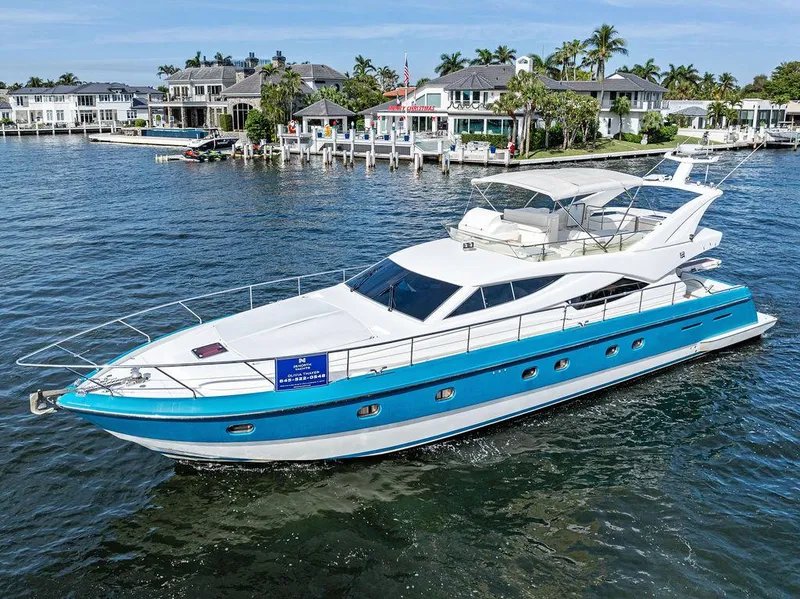 Slide: The Image of 2003 Ferretti Yachts 620 cruising on a scenic waterfront with luxury homes. - 2