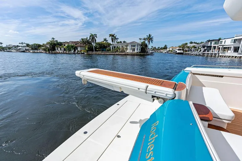 Slide: The Image of 2003 Ferretti Yachts 620 on serene waterfront with palm trees and luxury homes. - 9