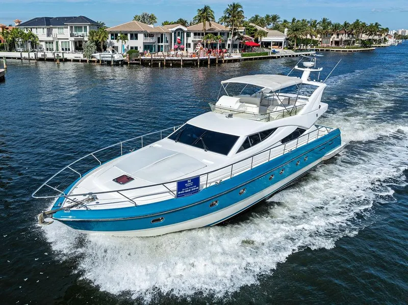 Slide: The Image of 2003 Ferretti Yachts 620 cruising on a scenic waterway near luxury homes. - 1