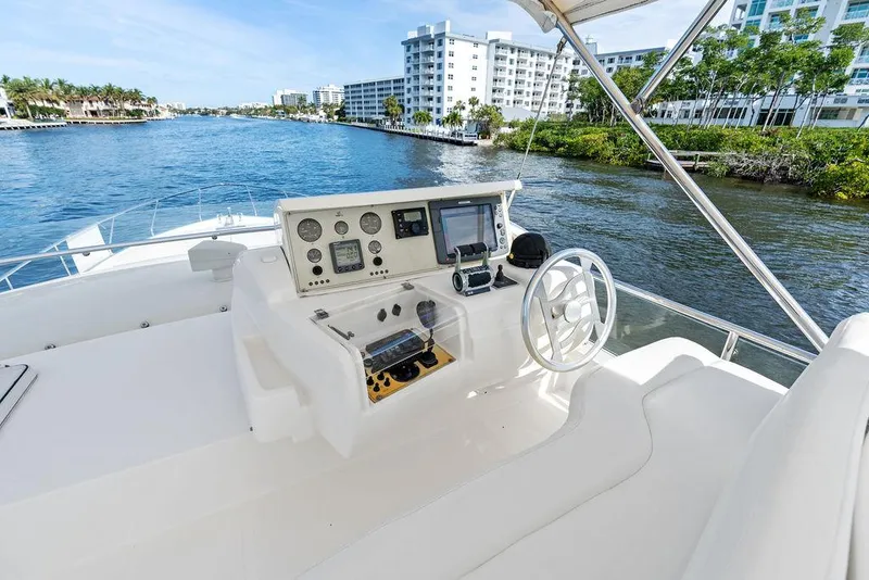 Slide: The Image of 2003 Ferretti Yachts 620 helm with modern controls, cruising on a scenic waterway. - 15