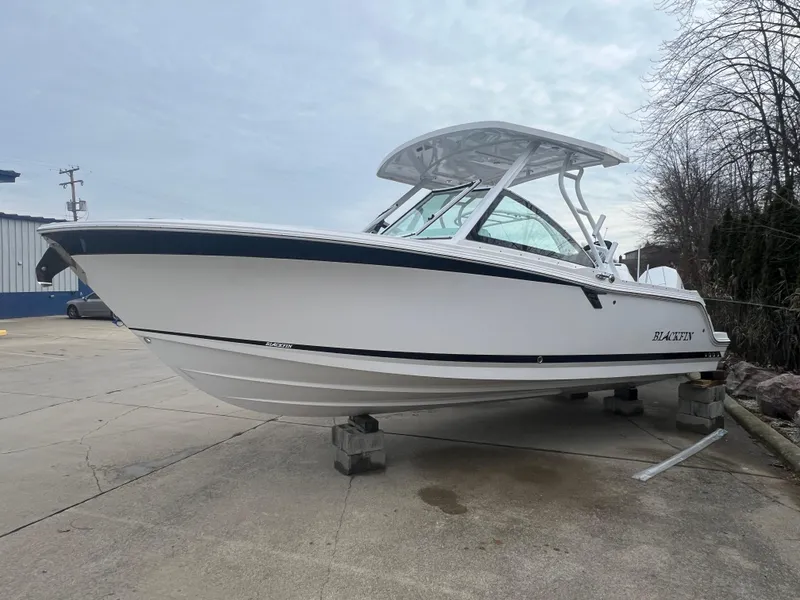 The Image of 2024 Blackfin 252 DC boat on display in a parking lot. - 0