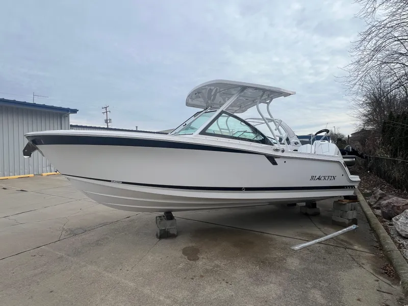 Slide: The Image of 2024 Blackfin 252 DC boat on display in a parking lot. - 1