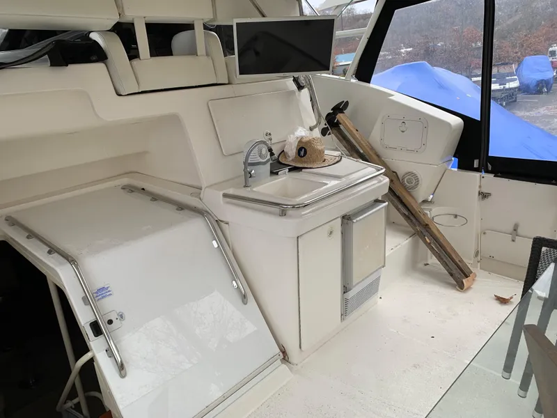 Slide: The Image of 2000 Silverton 392 Motor Yacht interior with sink, storage, and seating area. - 1