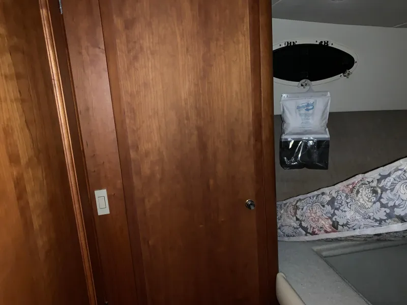 Slide: The Image of Interior cabin of 2000 Silverton 392 Motor Yacht with wooden door and patterned bedding. - 12
