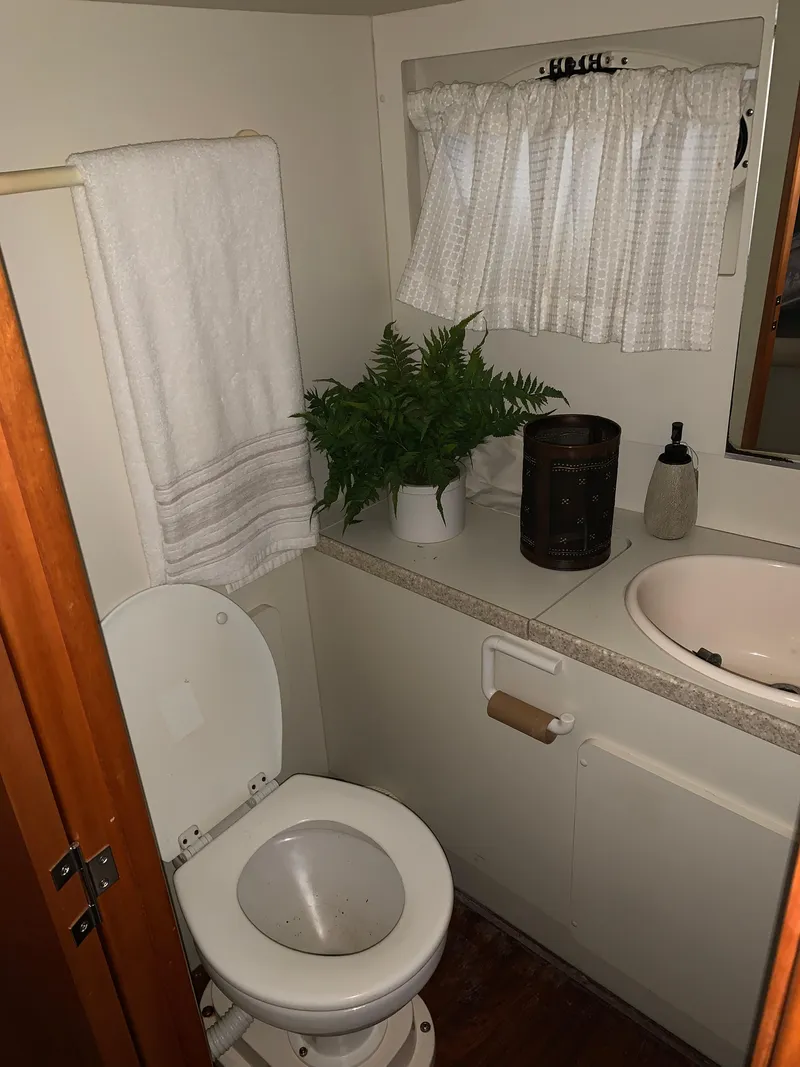 Slide: The Image of Bathroom interior of 2000 Silverton 392 Motor Yacht with toilet, sink, and decor. - 17