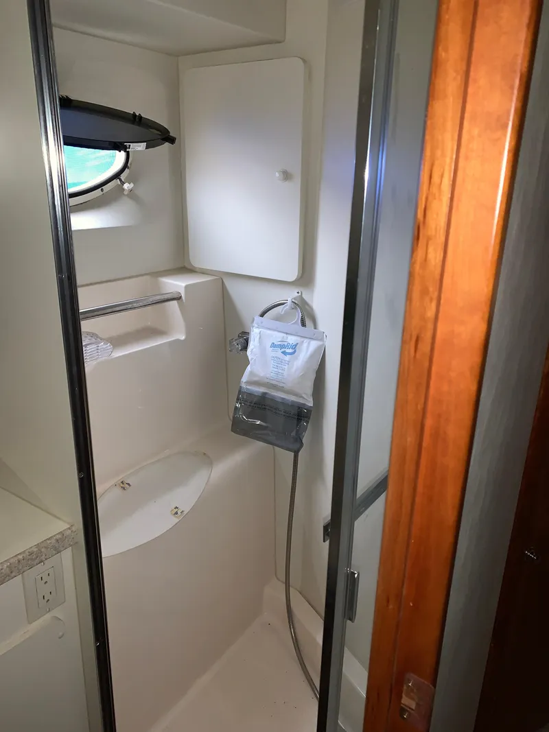 Slide: The Image of Bathroom interior of 2000 Silverton 392 Motor Yacht with shower and porthole window. - 18