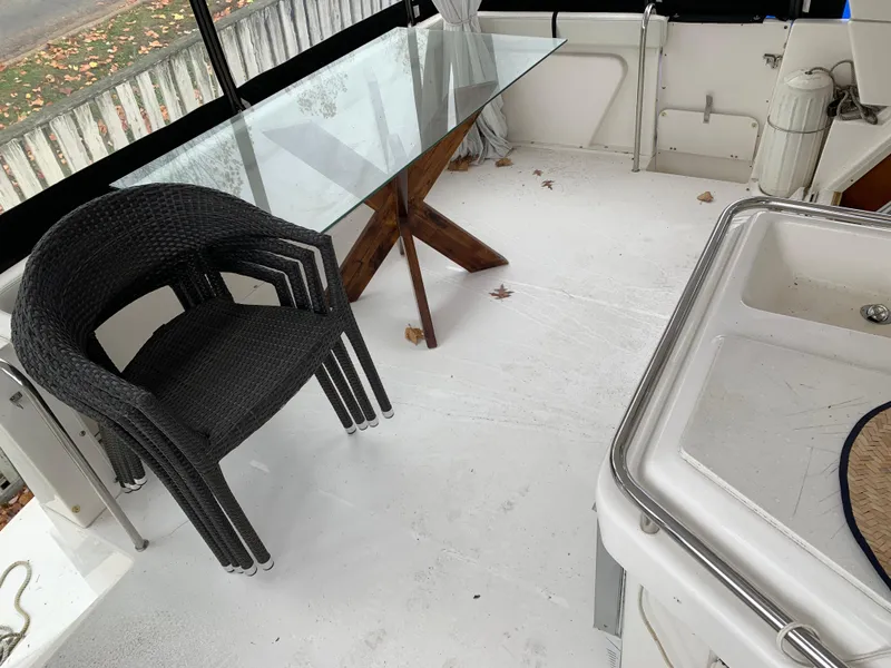 Slide: The Image of 2000 Silverton 392 Motor Yacht deck with glass table and wicker chairs. - 2