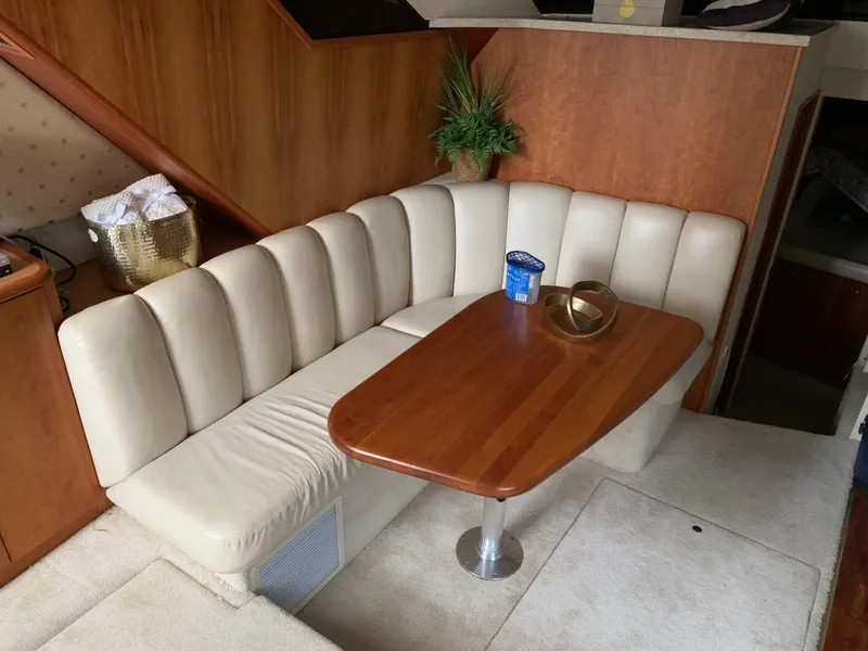Slide: The Image of Interior of 2000 Silverton 392 Motor Yacht with beige seating and wooden table. - 5