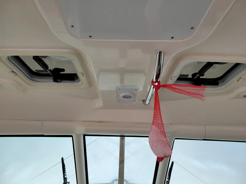 Slide: The Image of Interior ceiling of 2012 Pursuit 315 Offshore boat with hatches and red netting. - 18