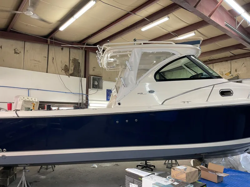 Slide: The Image of 2012 Pursuit 315 Offshore boat in a workshop setting. - 2
