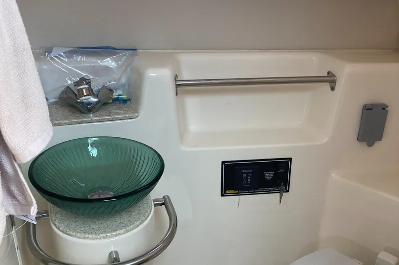 Slide: The Image of 2012 Pursuit 315 Offshore bathroom with glass sink and modern fixtures. - 24