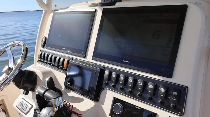 Slide: The Image of 2023 Grady-White 281 Coastal Explorer boat dashboard with navigation screens and controls. - 36