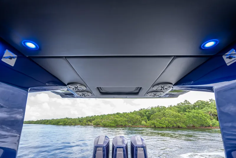 Slide: The Image of 2024 Nor-Tech 450 Sport Center Console, rear view with engines and scenic water backdrop. - 11