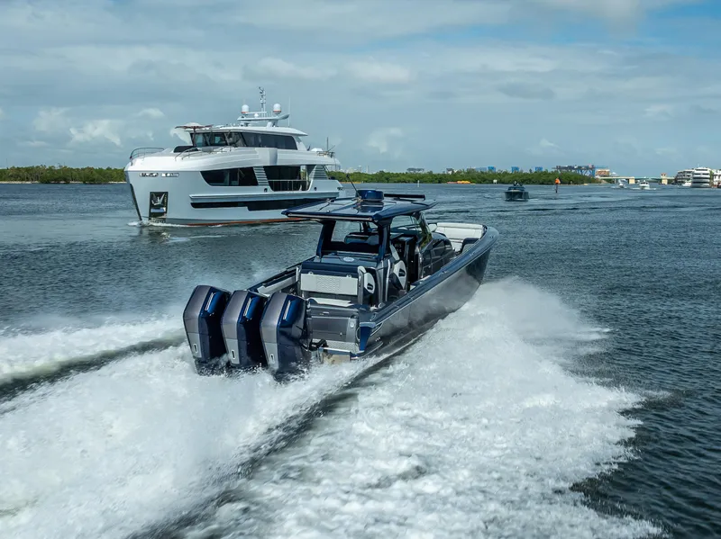 Slide: The Image of 2024 Nor-Tech 450 Sport Center Console speeding on water, with yacht in background. - 13