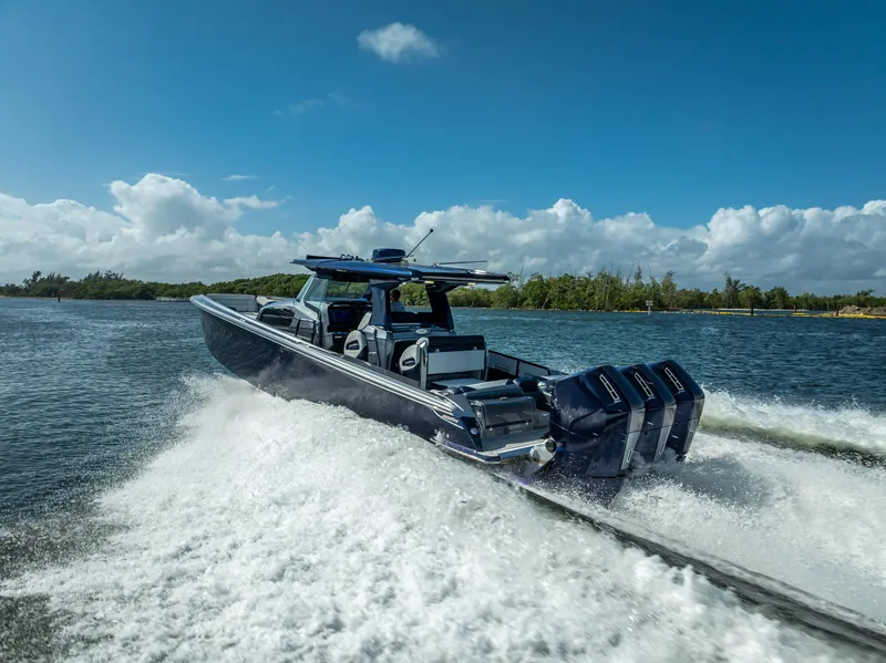 Slide: The Image of 2024 Nor-Tech 450 Sport Center Console speeding on water under clear blue sky. - 16