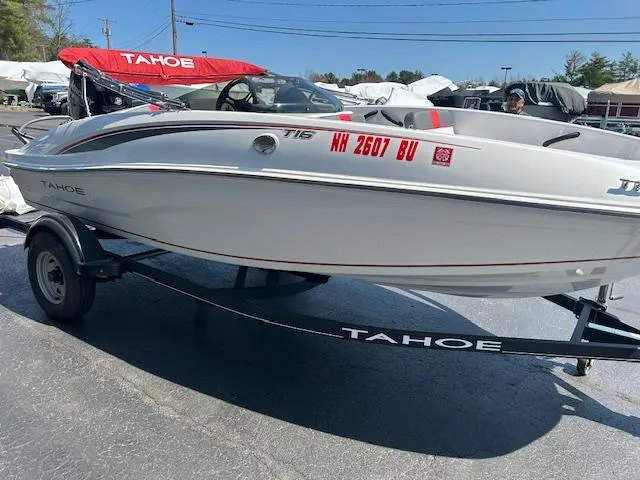 Slide: The Image of 2022 Tahoe T16 boat on trailer, white with red accents, parked outdoors. - 11